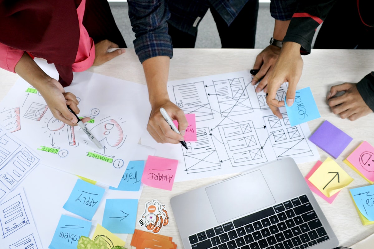 Design team sketching app wireframes on paper